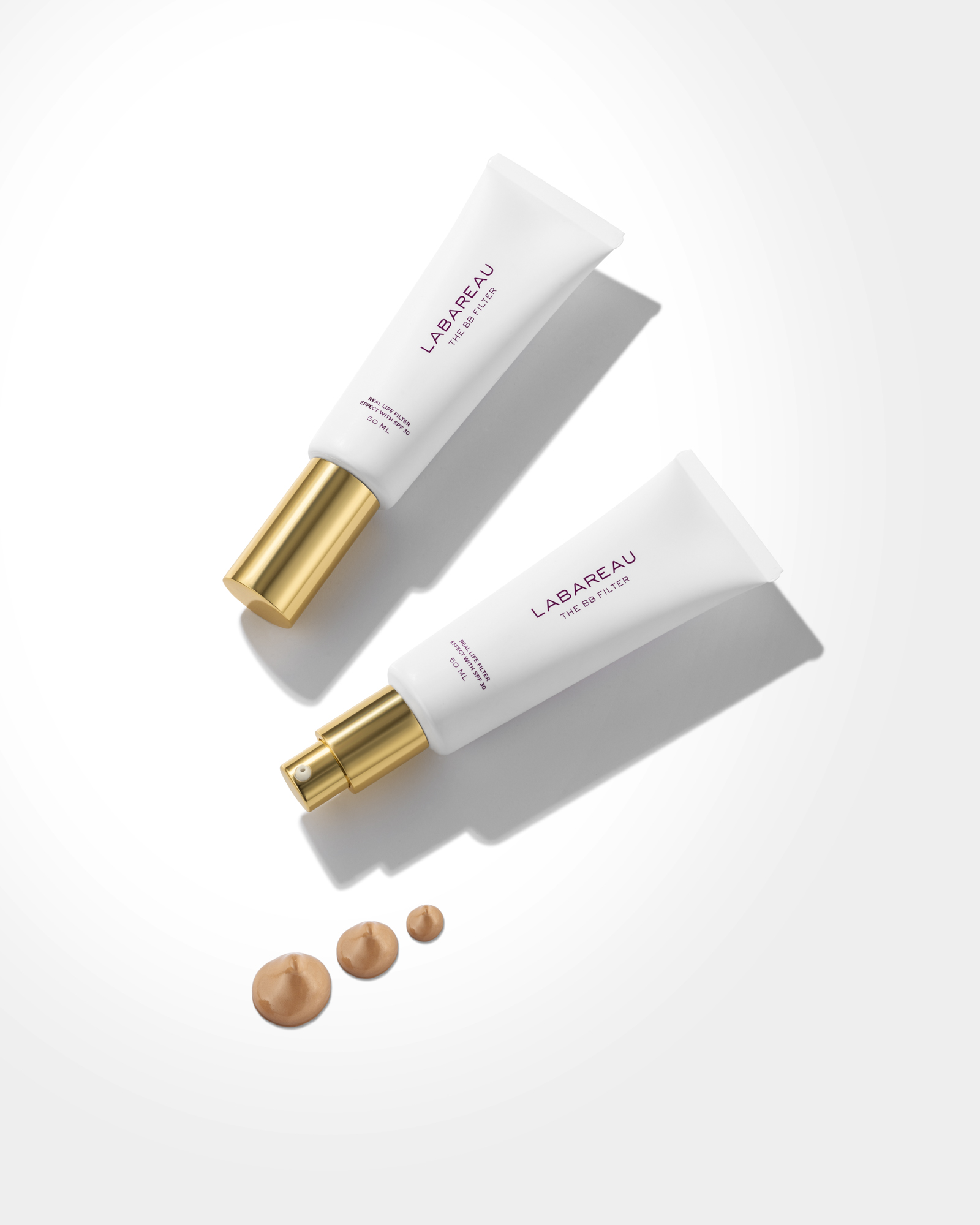 Creatieve cosmetica productfotografie van twee Labareau BB Filter tubes met gouden verpakkingdetails en foundationtextuur op witte achtergrond.