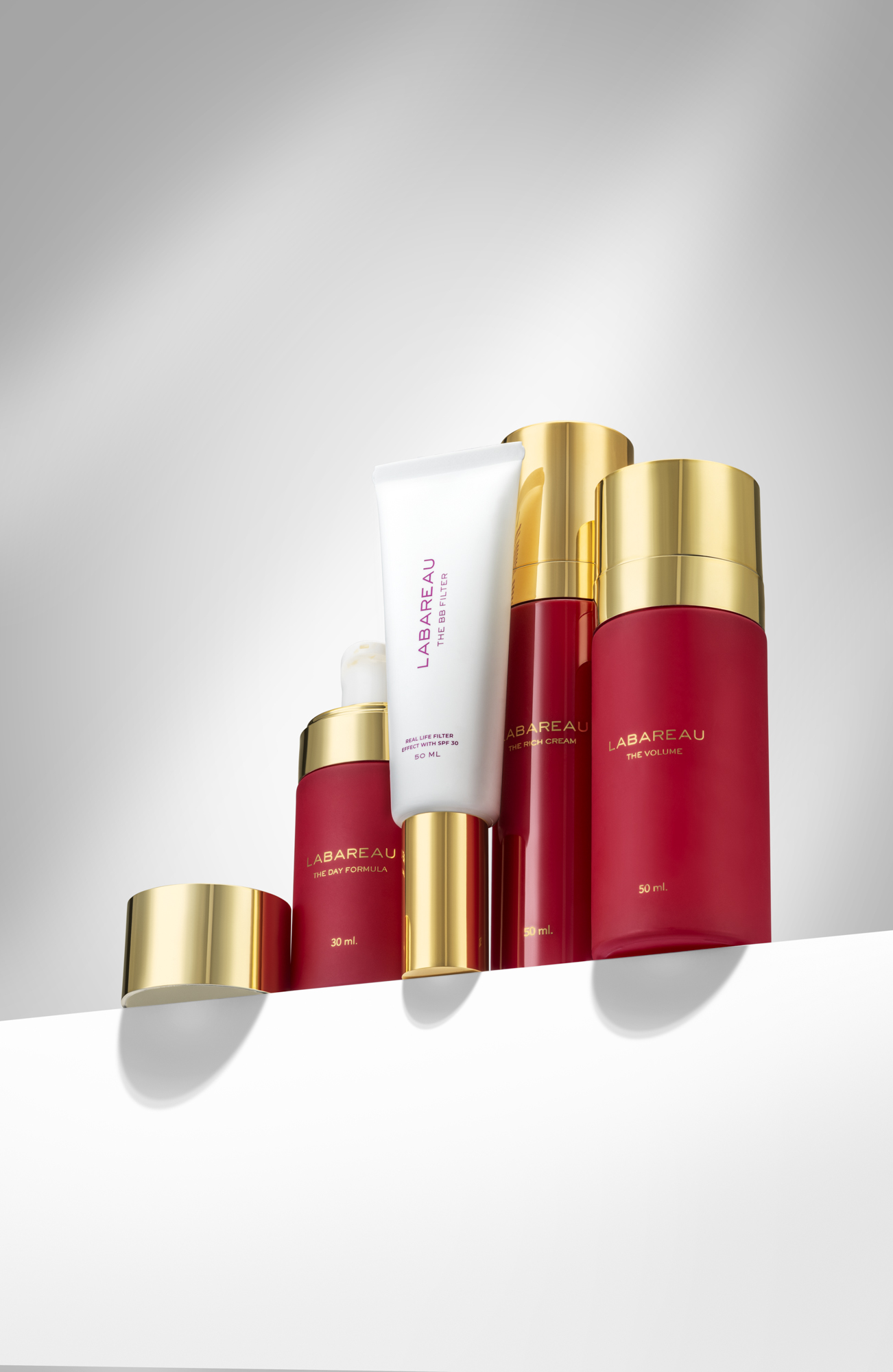 Professionele skincare productfotografie van meerdere Labareau gezichtsverzorgingsproducten met rood-gouden verpakking.