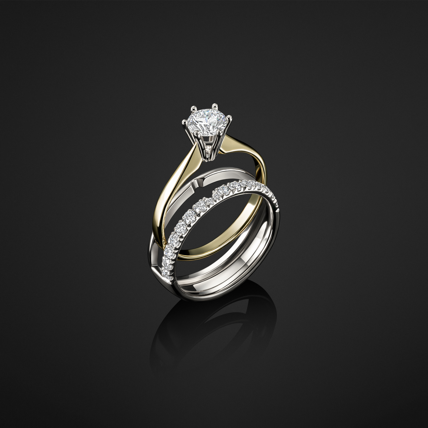 Professionele productfoto van gouden en witgouden ringen met edelstenen, gefotografeerd op zwarte reflecterende ondergrond.