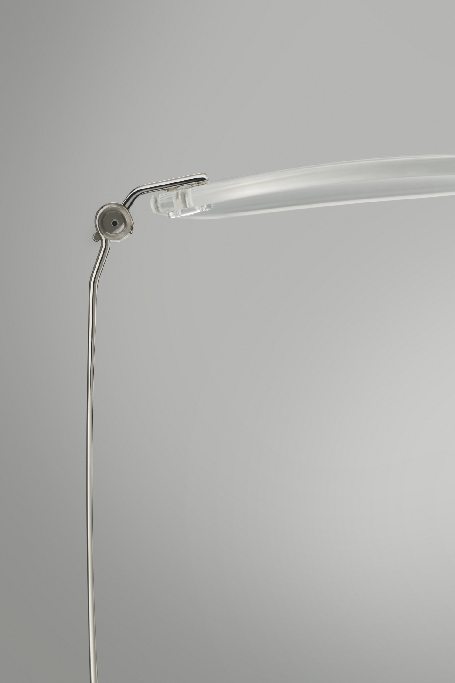 Detailfoto van randloze bril met metalen scharnier en transparante brilpoot, professioneel gefotografeerd in studio.
