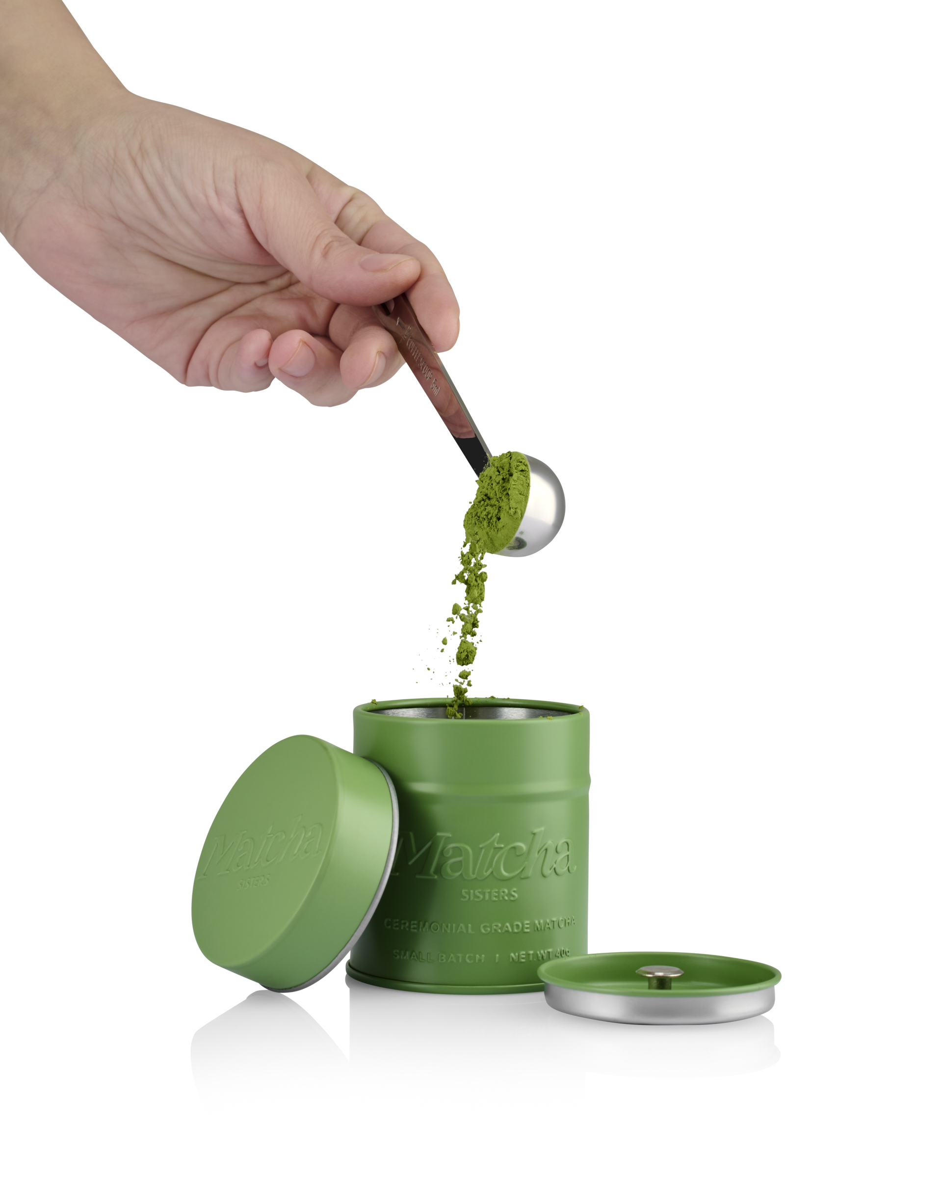 Creatieve productfotografie van Matcha Sisters matcha waarbij groen matchapoeder met een maatschep in de verpakking wordt gedaan.