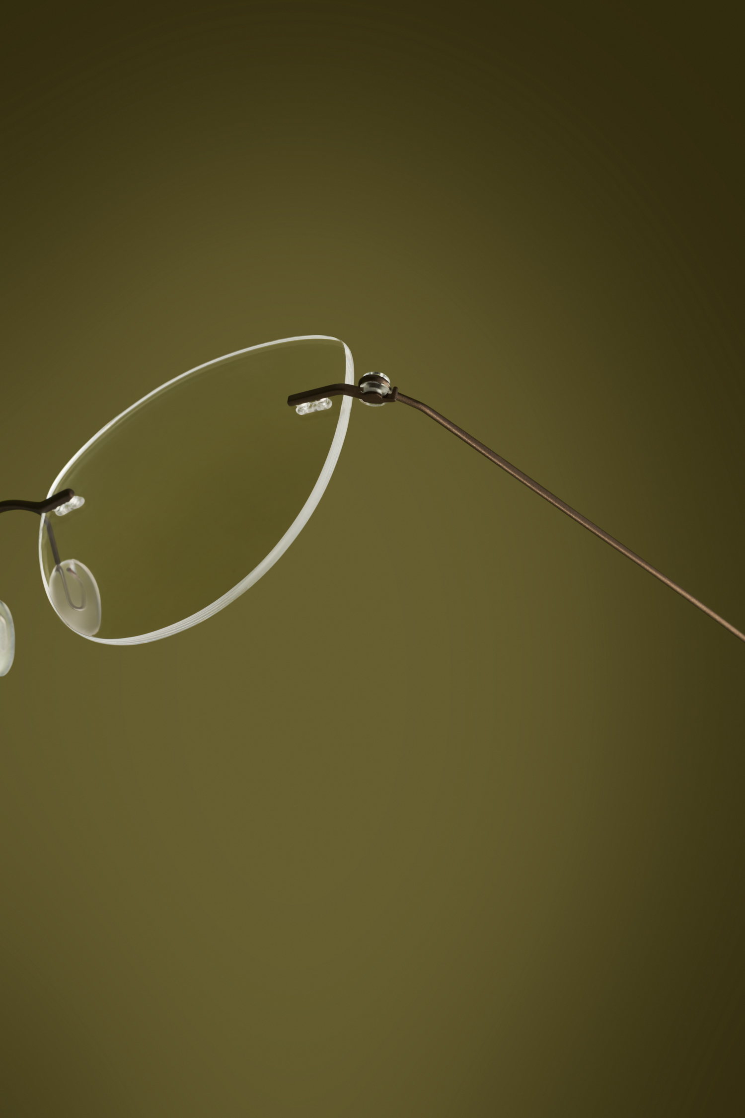 Professionele brillenfotografie en productfotografie van een randloos montuur met metalen details voor eyewear merk en reclamecampagne.