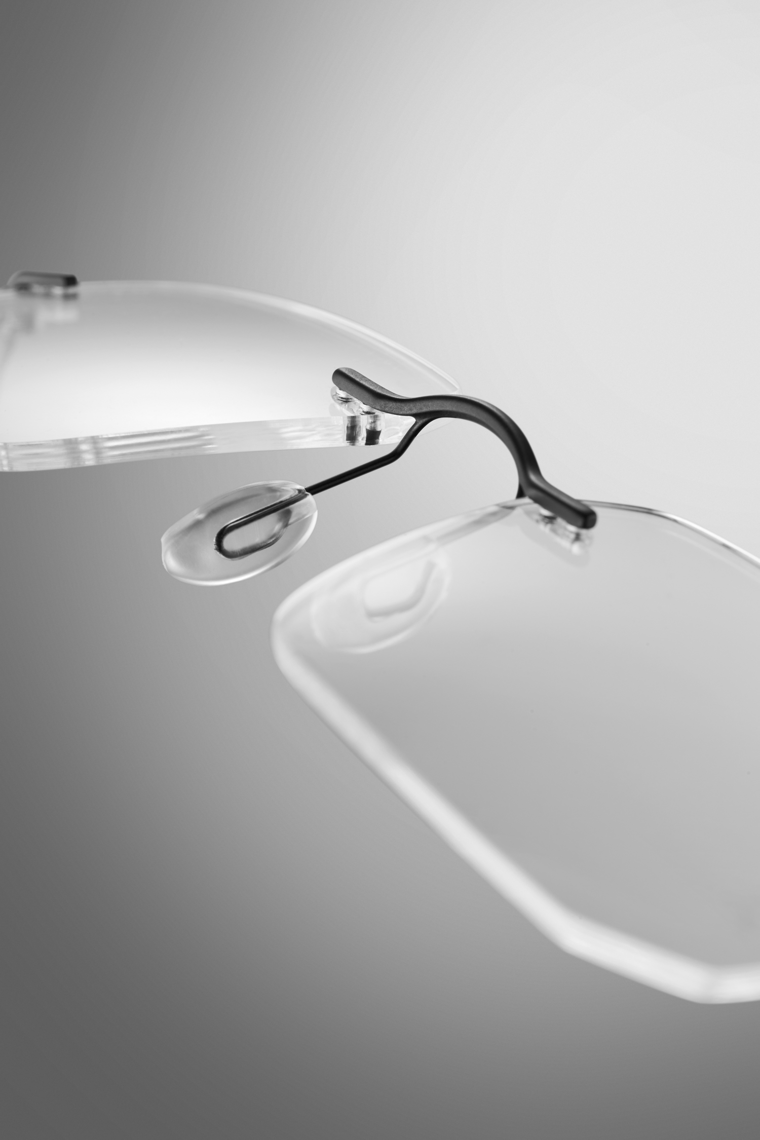 Macro productfotografie van een randloze bril met focus op neusbrug, neussteunen en fijne montuurdetails voor professionele brillenfotografie.